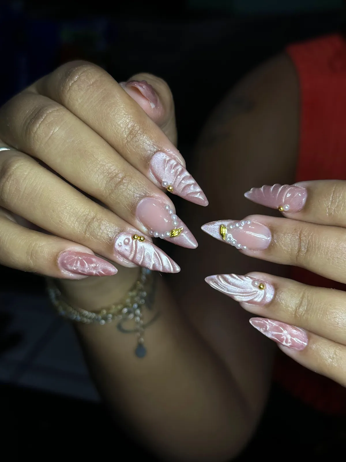 Alongamento molde F1 com nail art rosada e aplicações douradas