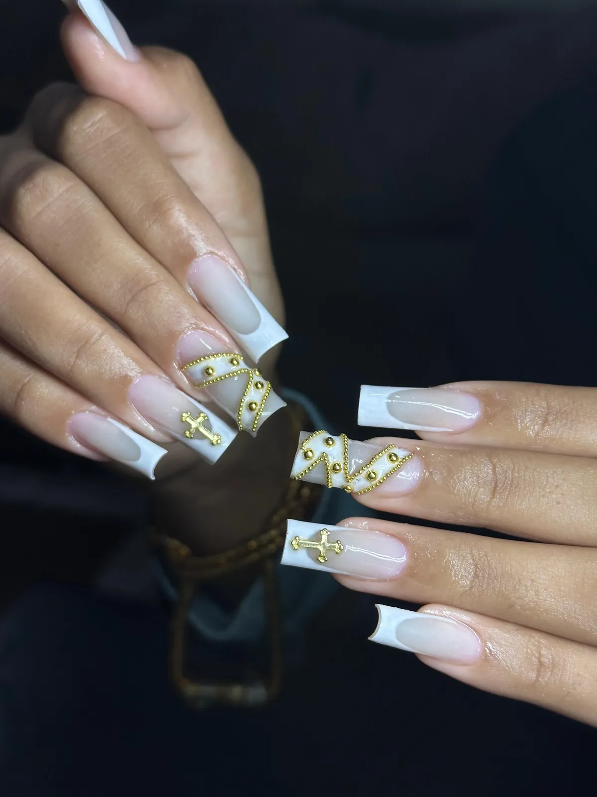 Nail art branca com aplicações e detalhes dourados